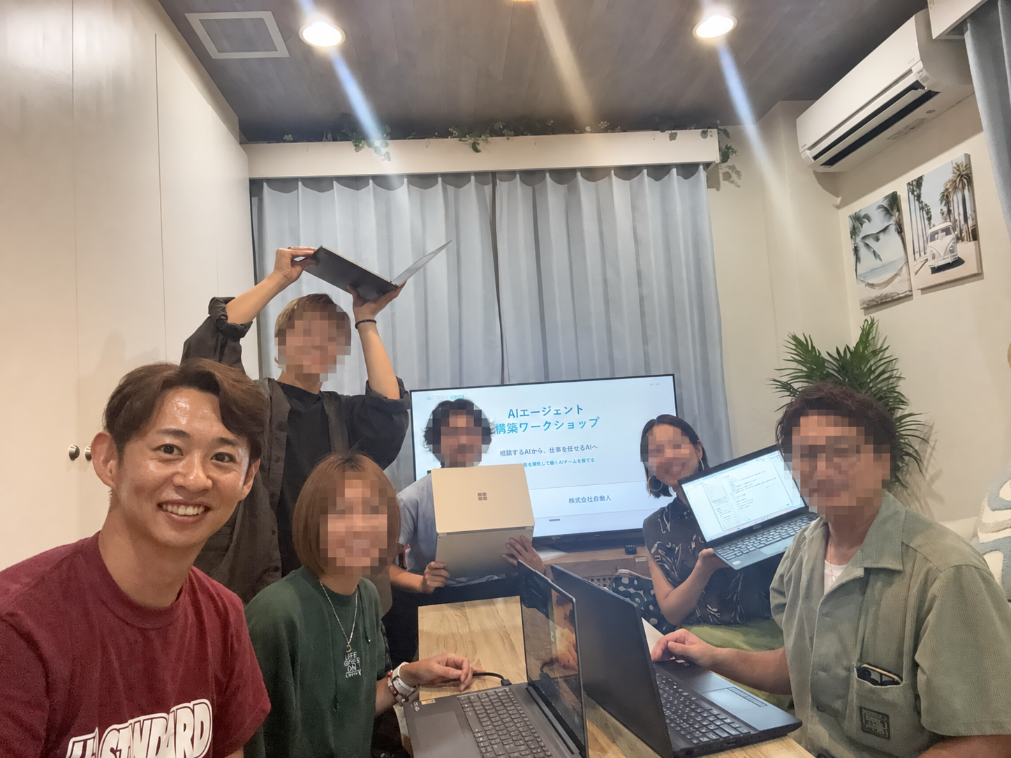 赤いシャツの主催者以外の顔をモザイク処理したワークショップの集合写真